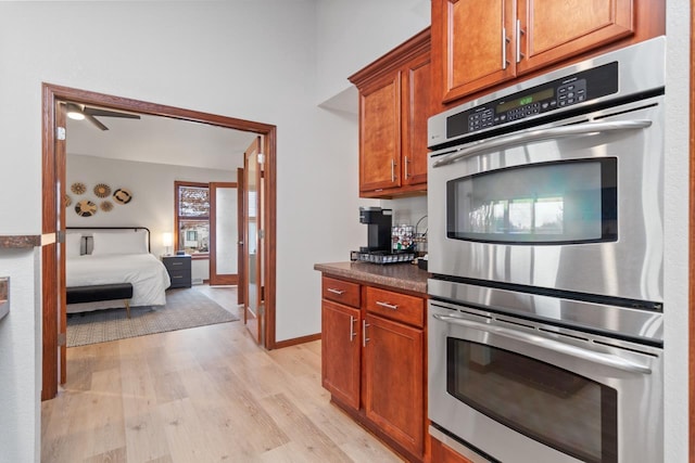 kitchen with stainless steel double oven and light wood-type flooring