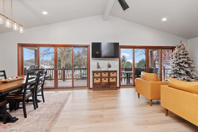 interior space featuring light wood-type flooring, a wealth of natural light, and lofted ceiling with beams