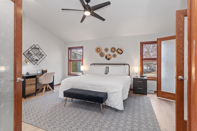 bedroom with ceiling fan, light hardwood / wood-style floors, and vaulted ceiling