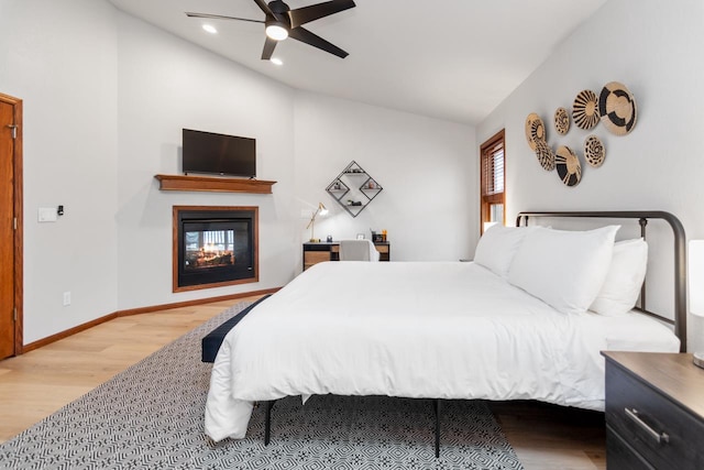 bedroom featuring ceiling fan, hardwood / wood-style flooring, and lofted ceiling