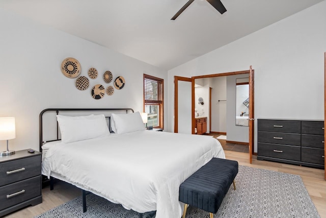 bedroom featuring ceiling fan, ensuite bath, light wood-type flooring, and lofted ceiling