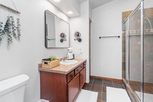 bathroom featuring toilet, vanity, an enclosed shower, and tile patterned flooring