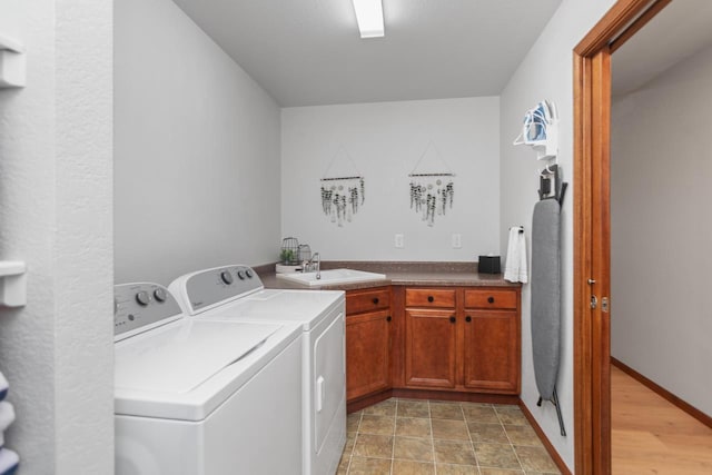 washroom featuring sink, separate washer and dryer, and cabinets