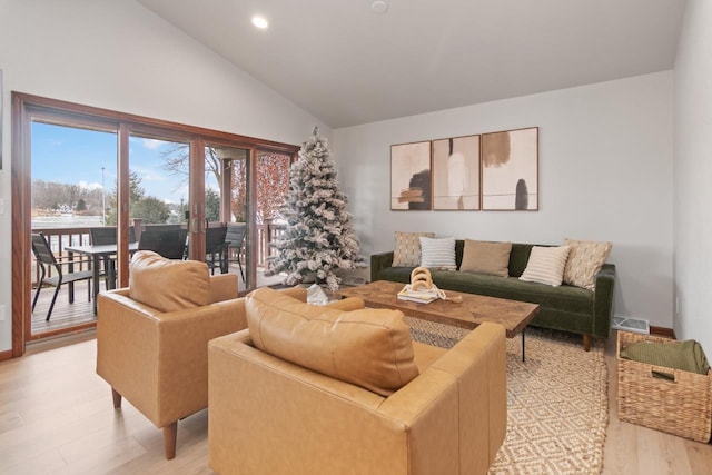 living room featuring lofted ceiling and light hardwood / wood-style floors