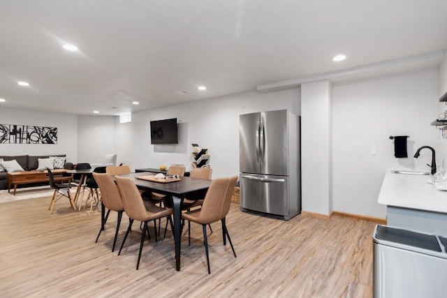 dining area featuring sink and light wood-type flooring