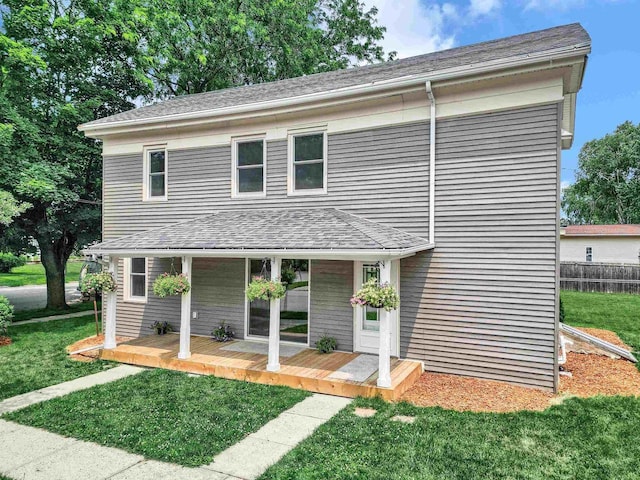 view of front of house with a wooden deck and a front lawn