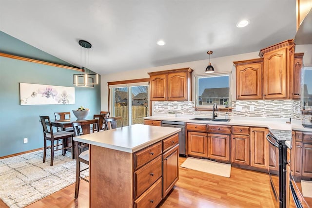 kitchen featuring backsplash, lofted ceiling, dishwasher, hanging light fixtures, and sink