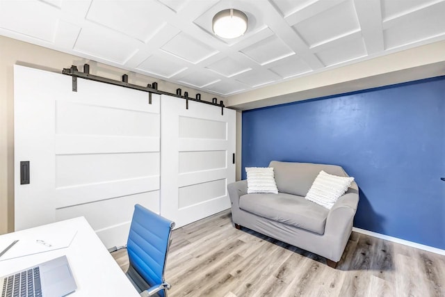 office area with light hardwood / wood-style flooring and coffered ceiling