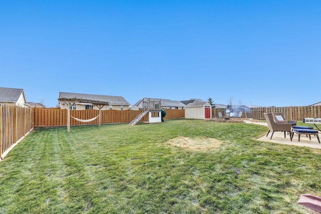 view of yard with a shed, a patio, and a playground