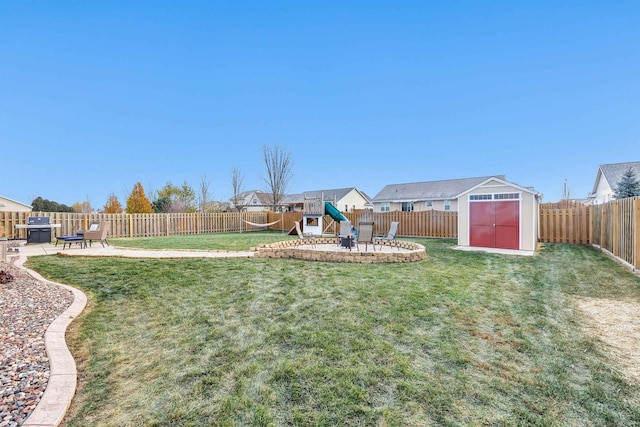 view of yard with a storage shed, a patio, and a playground