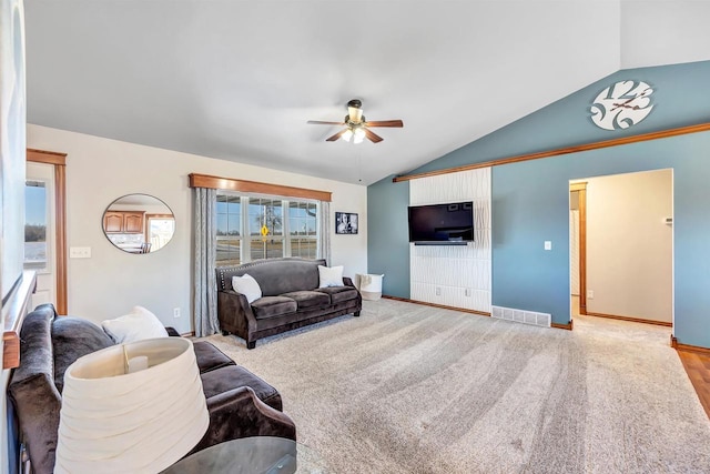 carpeted living room with ceiling fan and lofted ceiling