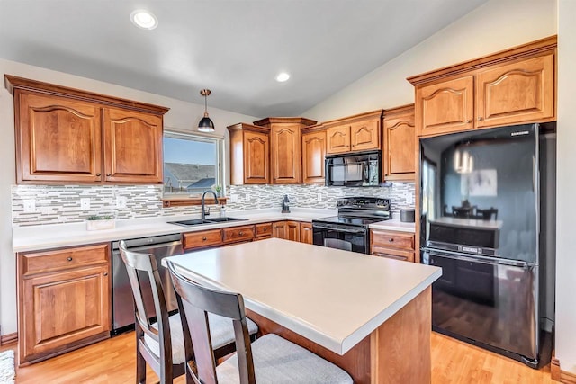 kitchen with black appliances, light wood-type flooring, sink, and lofted ceiling