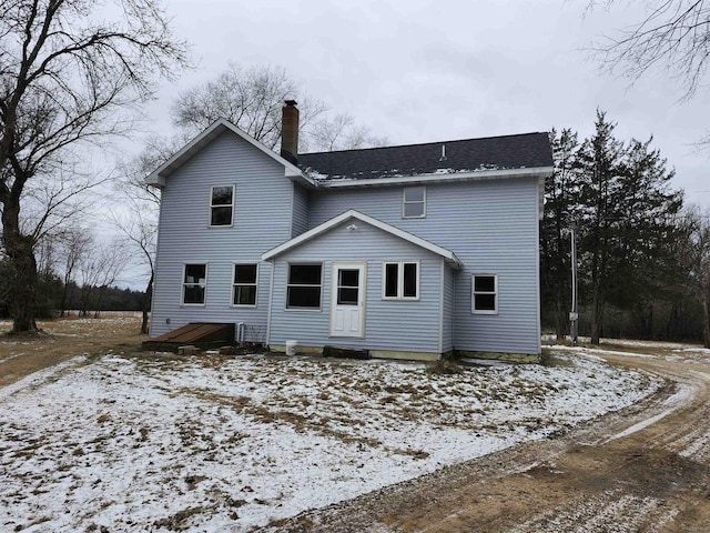 view of snow covered back of property