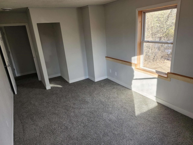 spare room featuring dark colored carpet