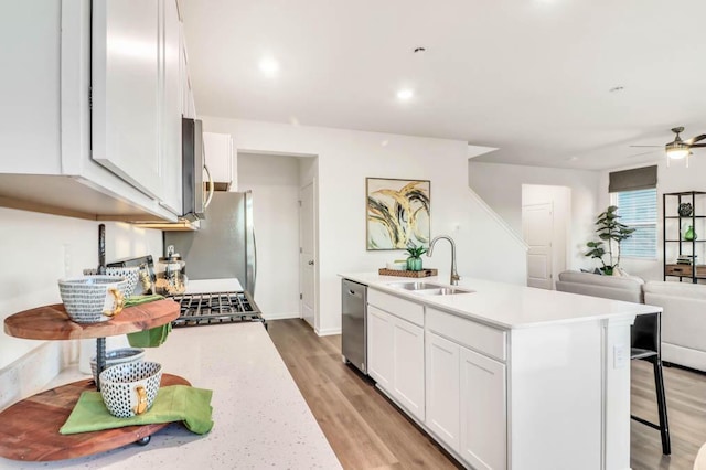 kitchen featuring a center island with sink, stainless steel appliances, white cabinets, and sink