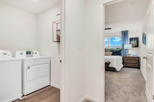 washroom with light hardwood / wood-style flooring and washing machine and clothes dryer