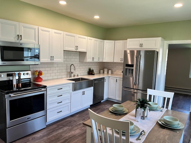 kitchen featuring decorative backsplash, sink, dark wood-type flooring, appliances with stainless steel finishes, and white cabinets