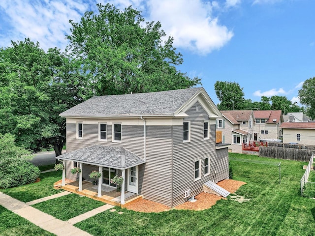 rear view of property featuring a lawn