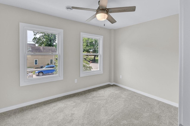 carpeted spare room featuring ceiling fan