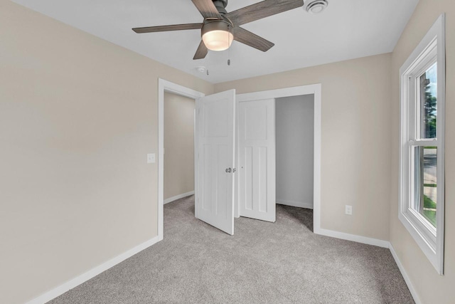 unfurnished bedroom featuring ceiling fan, light colored carpet, and a closet