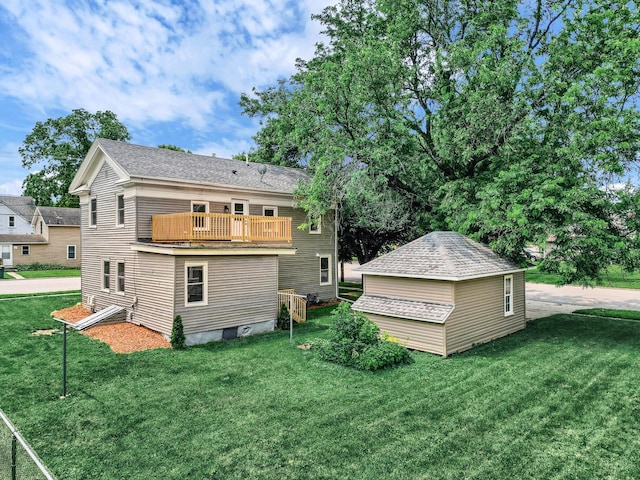 back of property featuring a balcony and a lawn