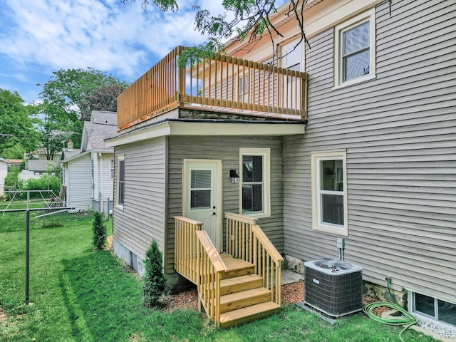 rear view of property featuring a balcony, cooling unit, and a yard