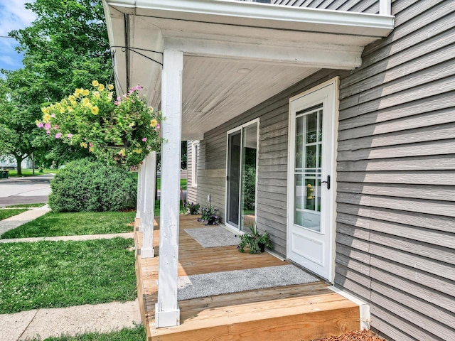 property entrance featuring a yard and a porch