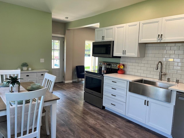 kitchen featuring decorative backsplash, sink, white cabinetry, stainless steel appliances, and dark hardwood / wood-style flooring