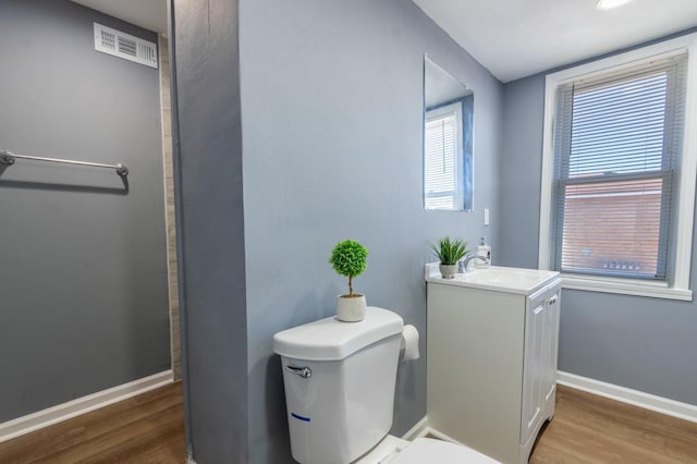 bathroom featuring toilet, hardwood / wood-style flooring, and vanity