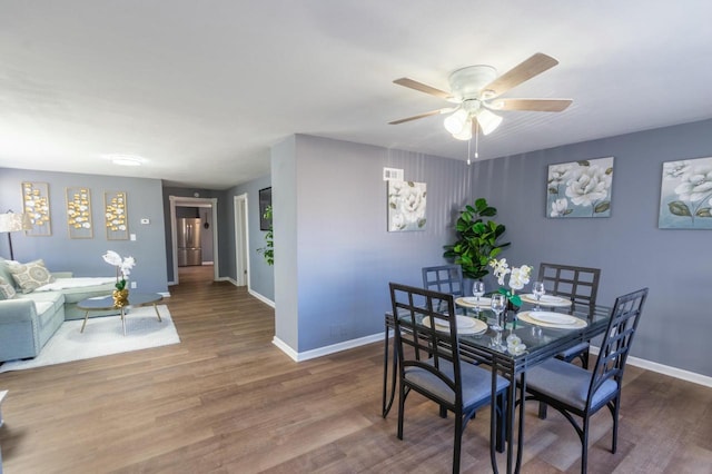 dining space with ceiling fan and wood-type flooring