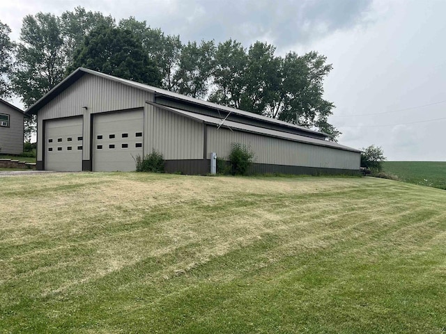 view of side of property featuring a garage, an outbuilding, and a yard