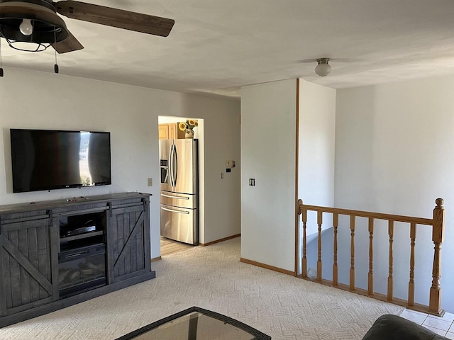 unfurnished living room featuring ceiling fan and light colored carpet