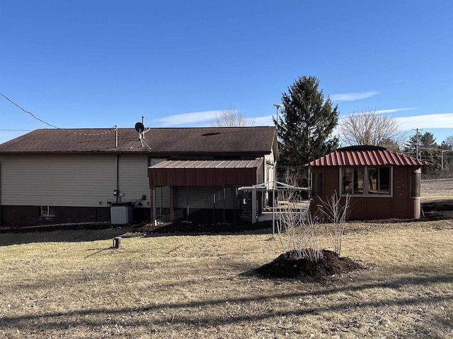 back of house with central AC and a yard