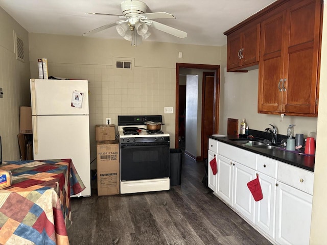 kitchen featuring white fridge, ceiling fan, gas stove, dark hardwood / wood-style flooring, and sink