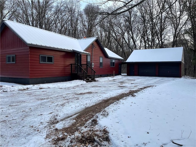 view of front of house with a garage and an outbuilding