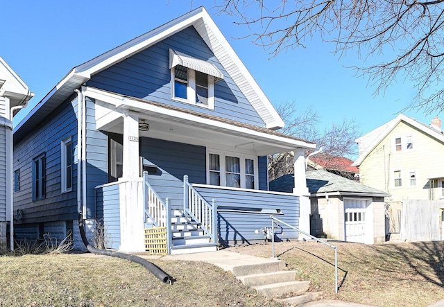 bungalow-style home featuring a garage, a front yard, and covered porch