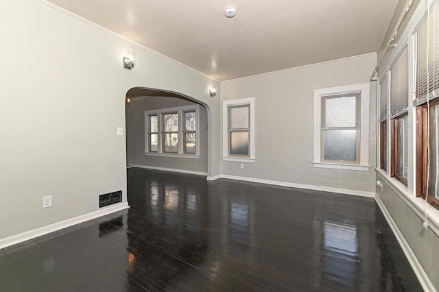 unfurnished room with dark hardwood / wood-style flooring, a wealth of natural light, and crown molding