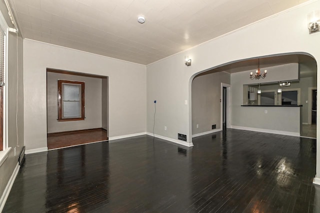 unfurnished room featuring dark hardwood / wood-style flooring, ornamental molding, and a chandelier