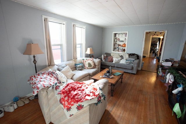 living room with built in features and wood-type flooring