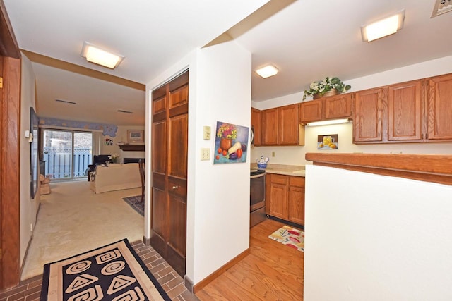 kitchen featuring light colored carpet and stainless steel electric range