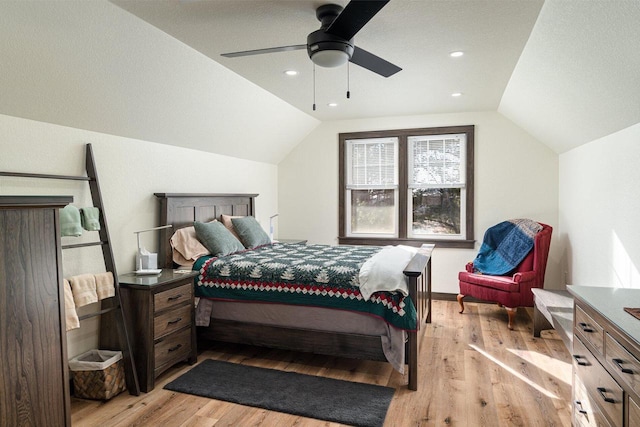 bedroom with ceiling fan, light hardwood / wood-style floors, and lofted ceiling