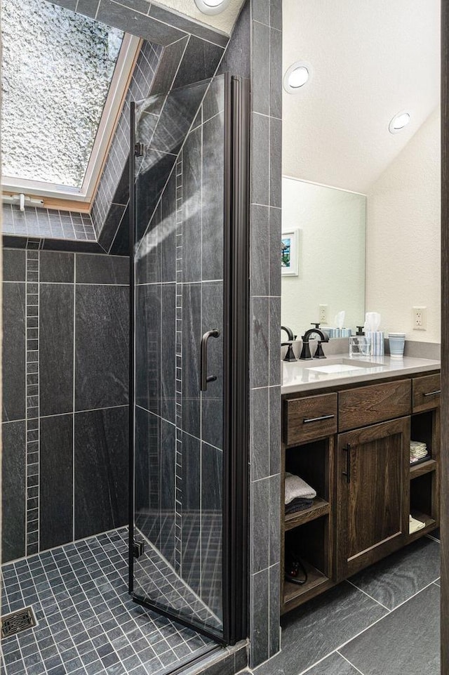 bathroom with walk in shower, lofted ceiling, vanity, and tile patterned flooring