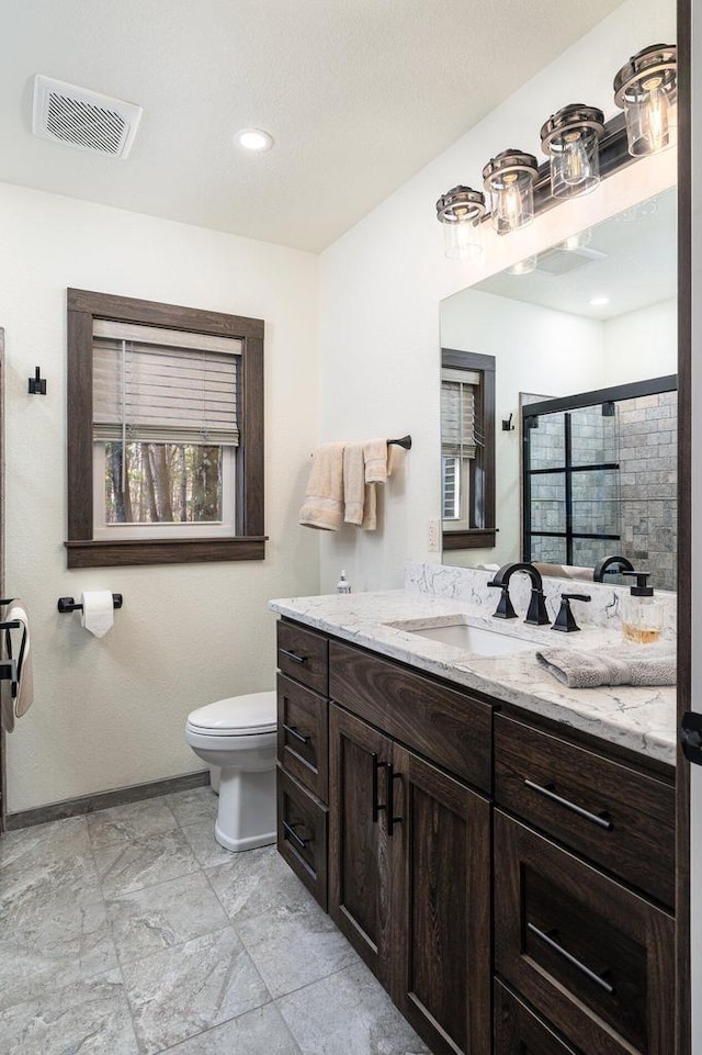 bathroom featuring an enclosed shower, vanity, and toilet