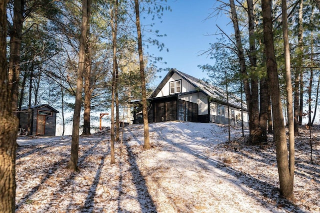 view of front facade featuring a storage unit and a sunroom