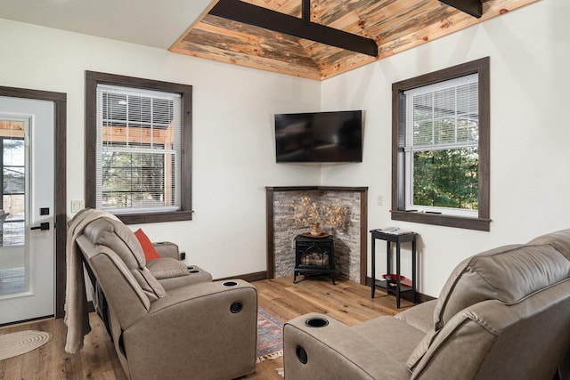 living room with wood ceiling, a wood stove, wood-type flooring, and lofted ceiling with beams