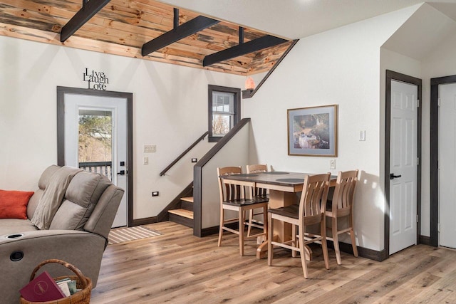 dining space with wood ceiling, light hardwood / wood-style floors, and lofted ceiling with beams