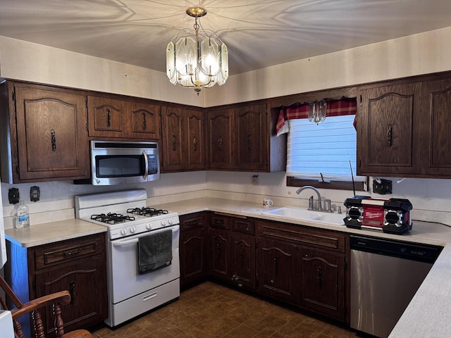 kitchen featuring decorative light fixtures, a notable chandelier, sink, dark brown cabinetry, and stainless steel appliances