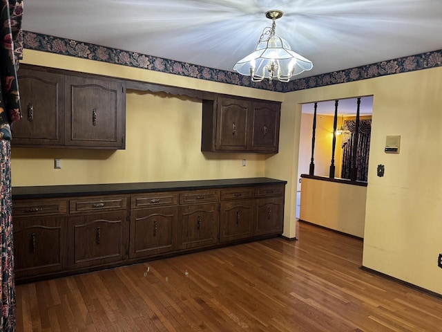 kitchen with hanging light fixtures, dark wood-type flooring, a chandelier, and dark brown cabinetry