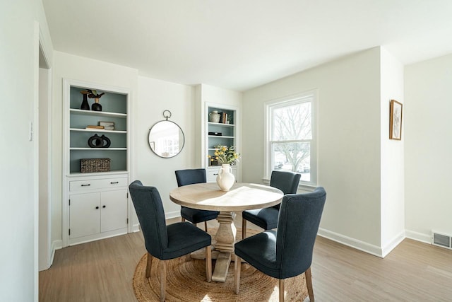 dining area featuring built in features and light hardwood / wood-style flooring