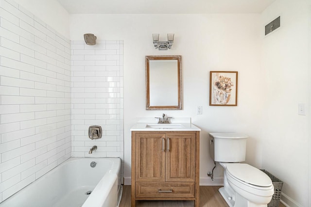 full bathroom featuring vanity, tiled shower / bath combo, and toilet